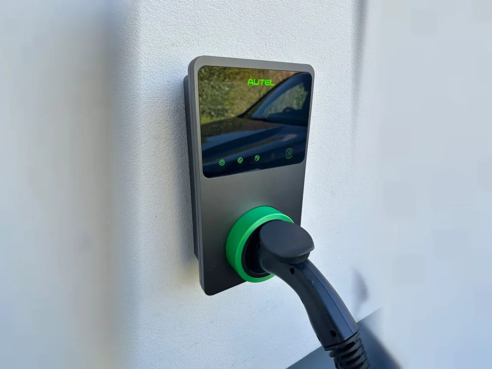 Borne de recharge Autel installée au mur, câble branché sur un véhicule électrique